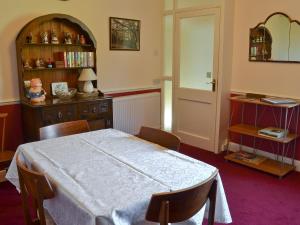 a room with a table and chairs and a book shelf at Suffolk House Annexe in Harrow on the Hill
