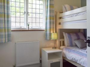 a bedroom with a bunk bed and a bedside table at Kingshill Farm Cottage - 28270 in Great Missenden
