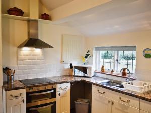 a kitchen with a sink and a stove at Kingshill Farm Cottage - 28270 in Great Missenden