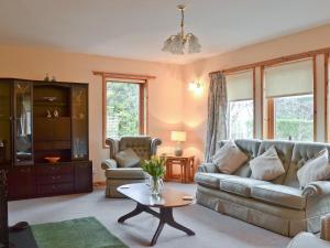 a living room with a couch and a table at Cotterton Beag in Nethy Bridge