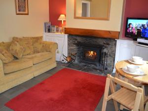 a living room with a couch and a fireplace at Fireside Cottagewindermere in Windermere