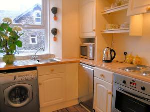 a kitchen with a washing machine and a sink at Fireside Cottagewindermere in Windermere