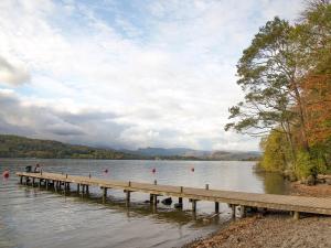 a dock on a lake with people on it at Fireside Cottagewindermere in Windermere