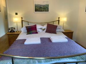 a bedroom with a large bed with purple sheets and pillows at Dipper in Malham