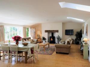 a living room with a table and chairs and a fireplace at Dove Cottage in Halesworth