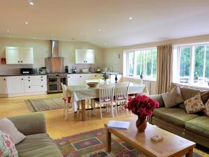 a living room with a table and a kitchen at Dove Cottage in Halesworth