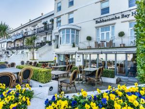 a restaurant with tables and chairs in front of a building at Oddicombe, Torquay in Torquay