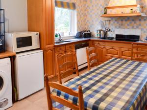 a kitchen with a table and a microwave at Culcharry Cottage in Cawdor