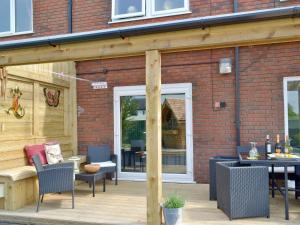 a patio with chairs and a table on a brick building at Hillcrest House in Endon