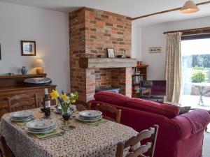 PeasmarshにあるPond Cottageのリビングルーム(テーブル、ソファ付)