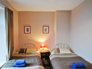 2 camas individuales en una habitación con lámpara en Long Row, en Hinderwell
