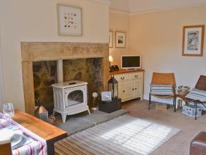 a living room with a fireplace and a stove at Grosvenor Cottage in Alnmouth