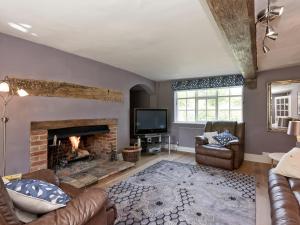 a living room with a fireplace and a tv at Cravens Manor in Sotherton