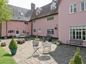 une terrasse avec des chaises et une table en face d'une maison dans l'établissement Cravens Manor, à Sotherton