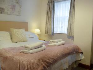 a bedroom with a bed with towels on it at Latrigg View in Keswick