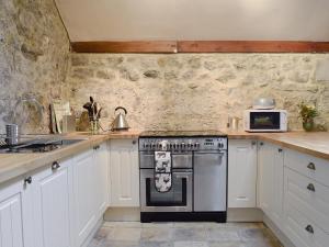 a kitchen with white cabinets and a stove at Sikes Laithe in Kilnsey