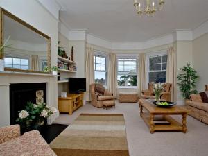 a living room with a fireplace and a mirror at Upper Knutsford in Exmouth