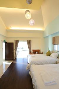 a hotel room with two beds and a large window at Taroko Bay B&B in Xincheng
