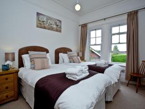 two twin beds in a bedroom with a window at Upper Knutsford in Exmouth