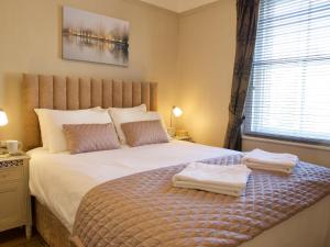 a bedroom with a bed with two towels on it at Quince Cottage - 25625 in Corbridge