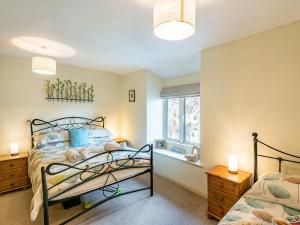 a bedroom with a bed and a window at Carries Gate in Coniston