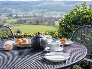 a table with a tea kettle and plates of food on it at Carries Gate in Coniston