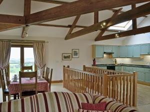 a kitchen and living room with wooden beams at New Park Farm - Church Cottage in Ireby