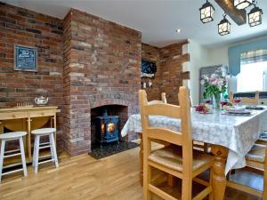 a living room with a brick wall and a table and a fireplace at Littlecot in Wyke Regis
