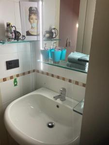een badkamer met een witte wastafel en een spiegel bij Casa CINEMA in Bergamo
