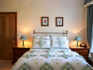 1 dormitorio con 1 cama con 2 lámparas y 2 cuadros en la pared en The Old Dairy, en Crosscanonby