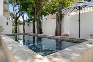 サンファンにあるVilla Bohemia - Gated Estate - 1 of 2の傘と木々のあるスイミングプール
