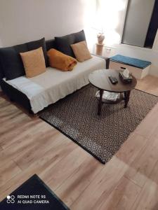 uma sala de estar com um sofá e uma mesa em logement Mezzanine salon indépendant em Mézières-sur-Seine