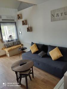 uma sala de estar com um sofá azul e uma mesa em logement Mezzanine salon indépendant em Mézières-sur-Seine