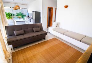 uma sala de estar com um sofá e uma cozinha em Casa nova completa a poucos passos da Praia do Mutà em Porto Seguro