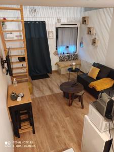 uma pequena sala de estar com um sofá e uma mesa em logement Mezzanine salon indépendant em Mézières-sur-Seine