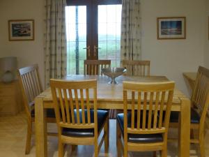 a dining room with a wooden table and chairs at Scobach Lodge in Turriff
