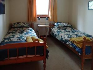 1 dormitorio con 2 camas y ventana en Scobach Lodge, en Turriff