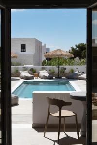 patio con tavolo, sedia e piscina di Drios Luxury Studios a Drios