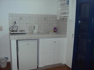 una pequeña cocina con fregadero y encimera en Princess Santorini Villa, en Perissa