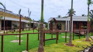 a resort with palm trees and a playground at Mirantes caminho do mar in Parnamirim