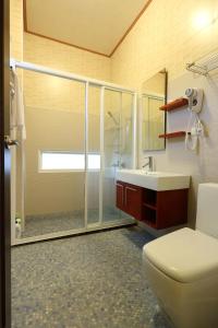 a bathroom with a shower and a toilet and a sink at Taroko Bay B&B in Xincheng