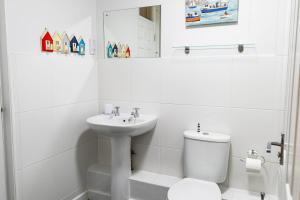 uma casa de banho branca com um WC e um lavatório em Valley Lodge 12 - Springer Lodge em Callington