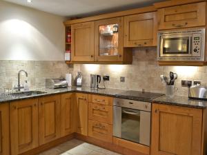 a kitchen with wooden cabinets and stainless steel appliances at Tidal Crest in Nottingham