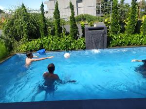 a group of men playing with a ball in a swimming pool at Villa Sky Garden in Bogor