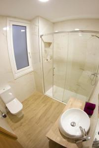 een badkamer met een douche, een toilet en een wastafel bij Ya no está disponible in A Coruña