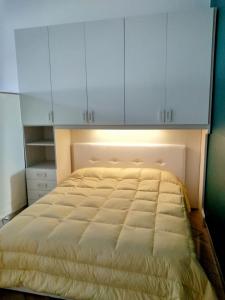 - une chambre avec un lit et des armoires blanches dans l'établissement Domus vacanze Alfieri, à Manfredonia