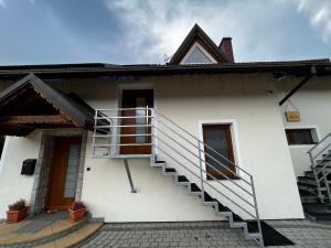 une maison blanche avec des escaliers sur son côté dans l'établissement Pokoje gościnne BROKAT, à Szczyrk
