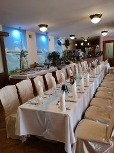 une rangée de tables avec des nappes blanches dans l'établissement HOTEL ŻUŁAWY, à Elbląg