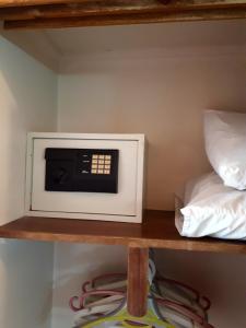 un microondas en un estante junto a una cama en New Pola Hotel, en Luxor
