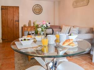 a glass table with food on it in a living room at Sweet Pea Cottage- 28322 in Holt